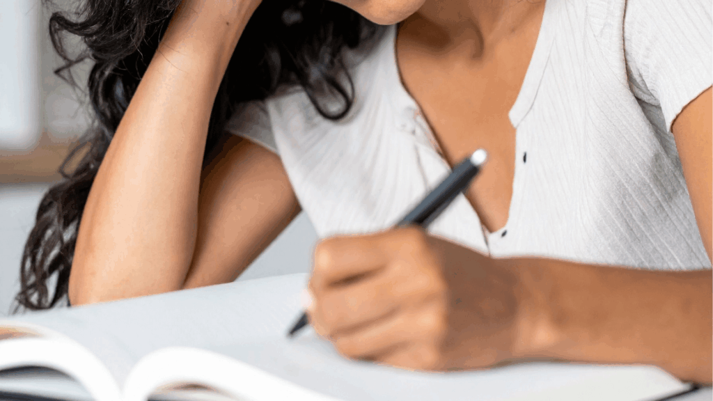 Wedding professional writing in a notebook while planning a wedding business marketing plan