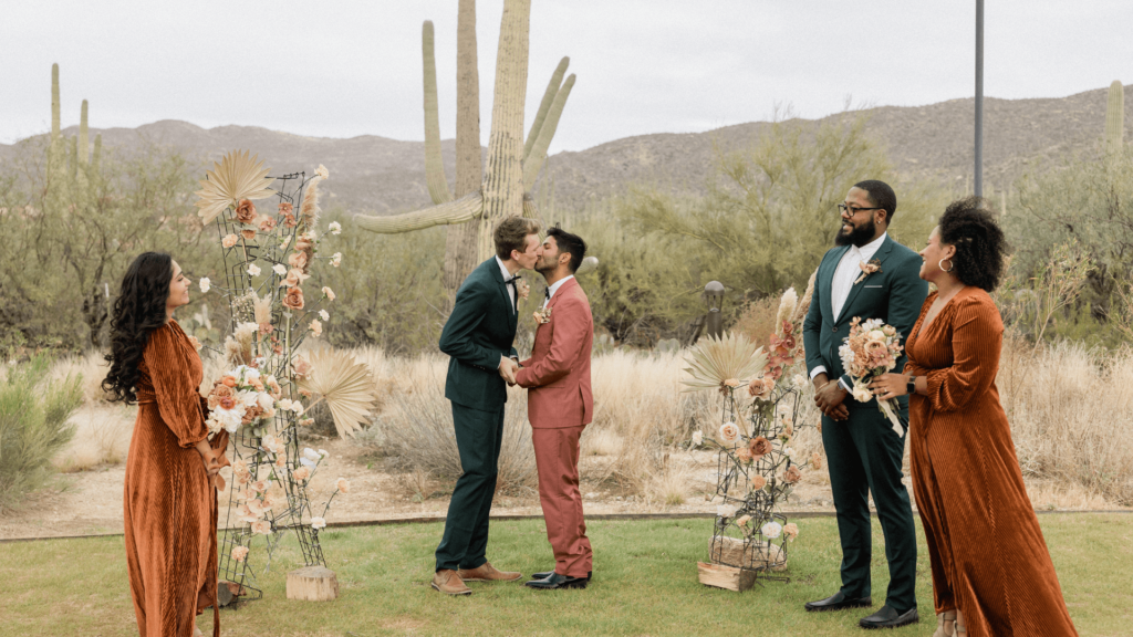 A beautiful outdoor wedding ceremony with two grooms exchanging vows, demonstrating the inclusive and diverse events managed with virtual assistant support.