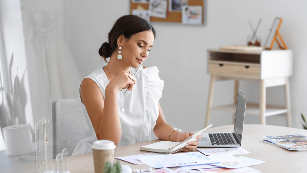 A wedding planner reviewing notes at a desk, highlighting the focus and creativity of a professional supported by a virtual assistant.