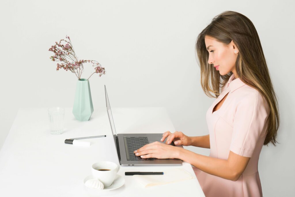 Wedding planner working on the computer on Honeybook workflows