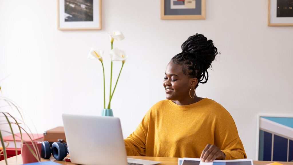 A woman working from home on her computer, excited and happy as she uses her CRM.