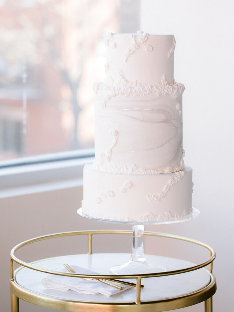 wedding cake on gold rimmed stand