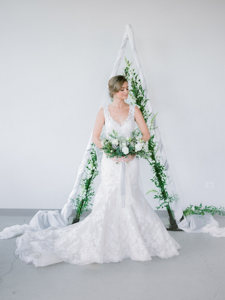 bride standing holding a bouquet of flowers at a photoshoot