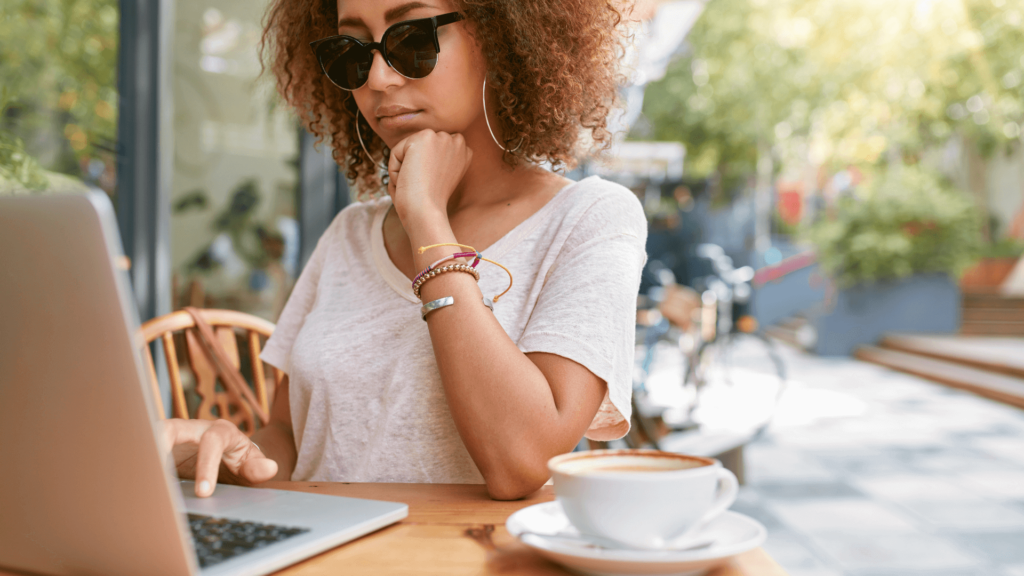 Wedding photographer sending an email submission for a bridal magazine feature while enjoying coffee outdoors.