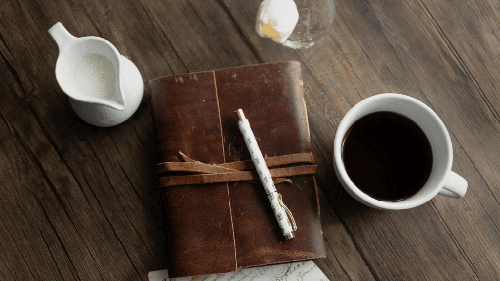 Journal and coffee representing the first step of a marketing workflow before organizing campaigns in Enji.