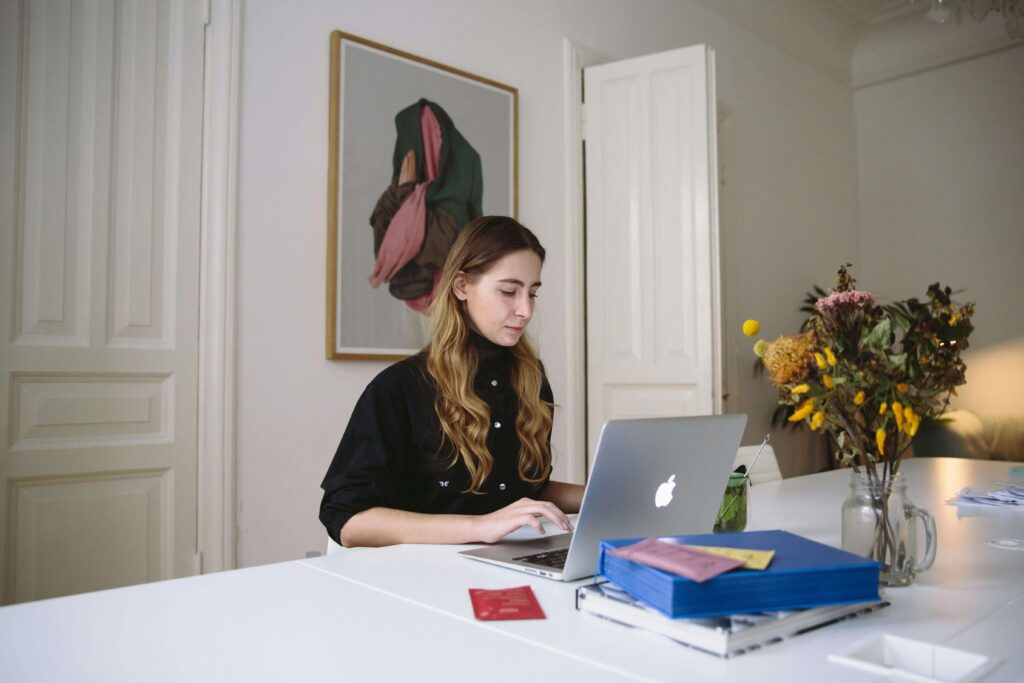 Woman entrepreneur planning on a computer, organizing a business calendar for wedding creatives.