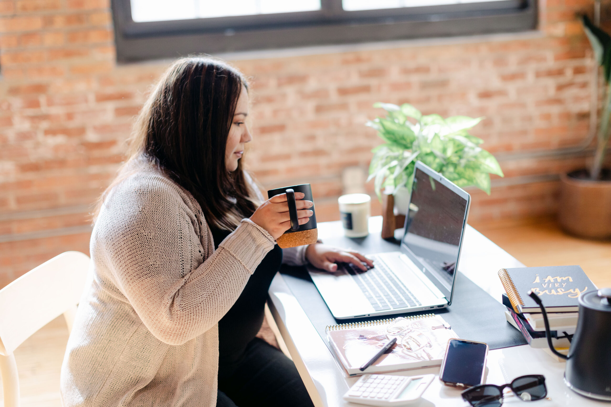 Cinthia Onines OBM working and drinking coffee