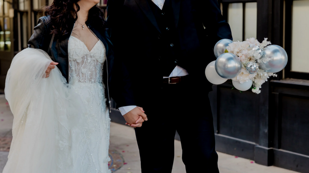 bride and groom wedding with balloon and flower bouquet, beaded gown, leather jacket, and groom with a black suit