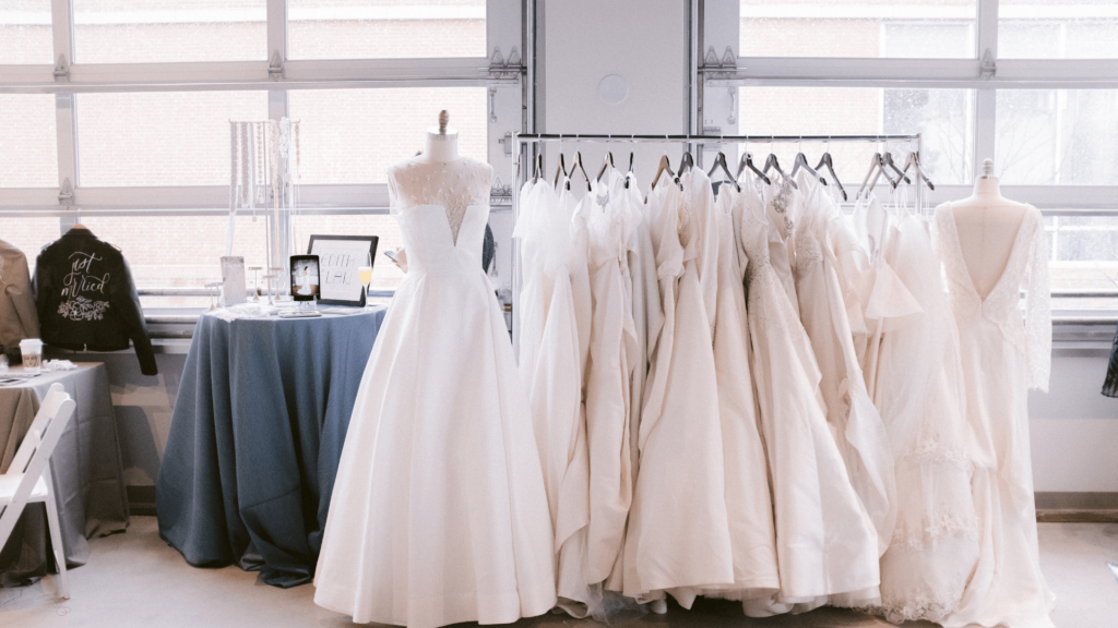 A bridal showroom with wedding dresses displayed on racks and a 'Just Married' jacket.