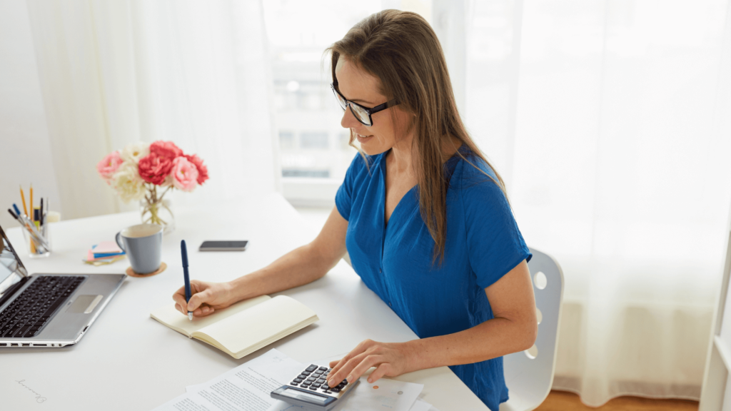  A wedding planner reviewing business finances, working on pricing strategies during engagement season.