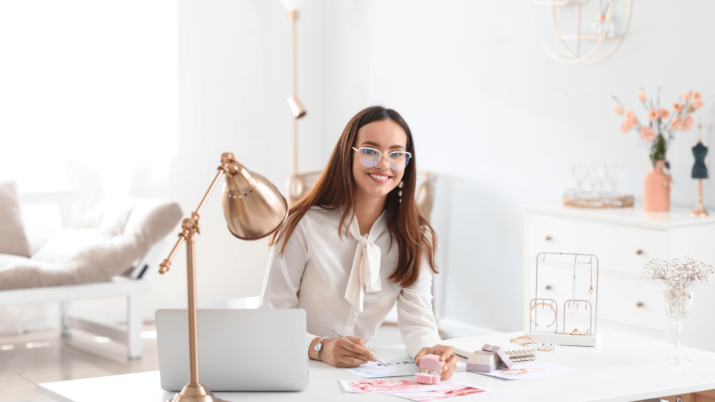 A wedding planner smiling at her desk with organized tools and wedding materials."