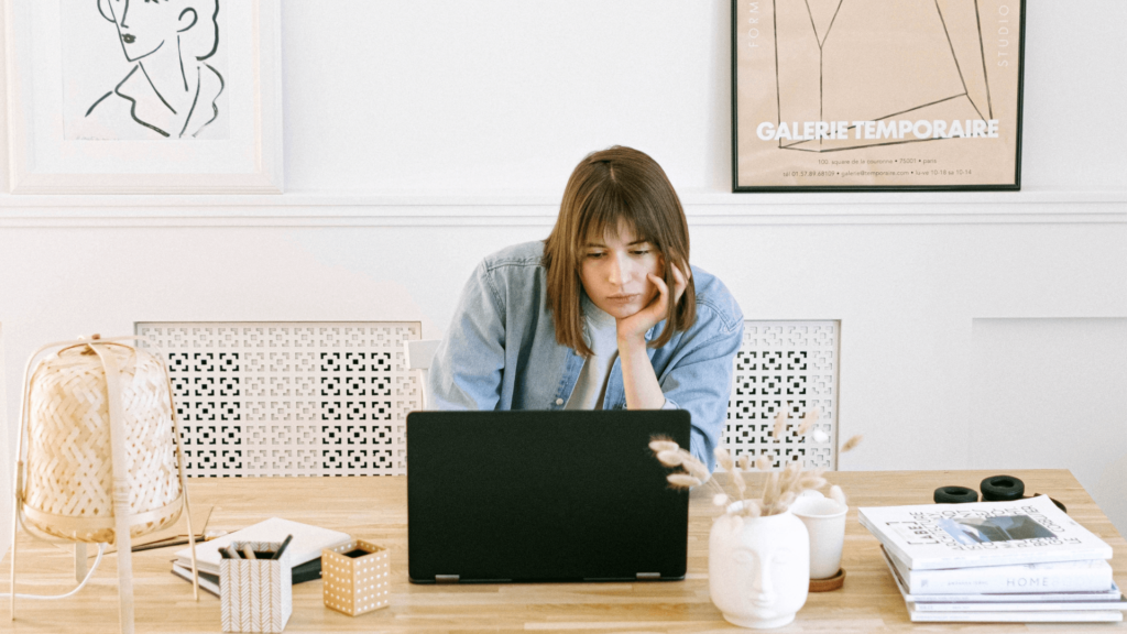 Woman analyzing marketing data on a laptop at a desk.