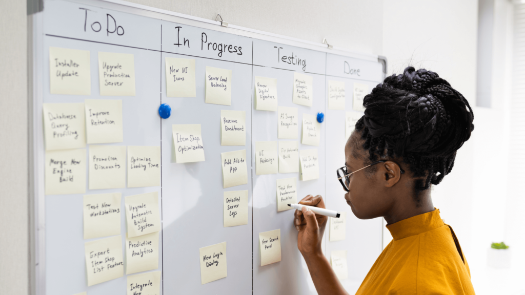  A businesswoman organizing her workflow on a task board, addressing inefficiencies in her CRM system to avoid CRM Mistakes.