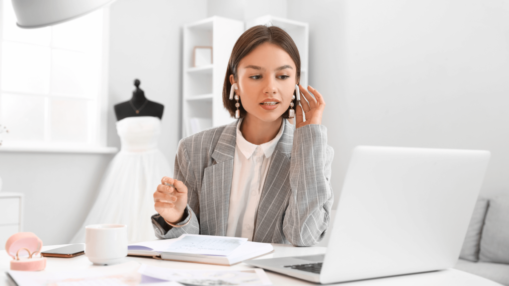 A stylish wedding professional in a chic gray blazer, working on her CRM system to correct common CRM Mistakes and streamline her client workflow.