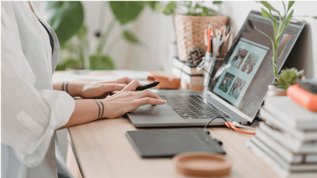 Creative business owner working on laptop to plan Pinterest strategy for wedding marketing during busy season.