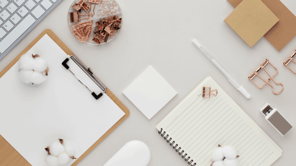 Laptop with growth chart and papers spread on desk, tracking KPIs and ROI metrics during a systems audit for wedding professionals.
