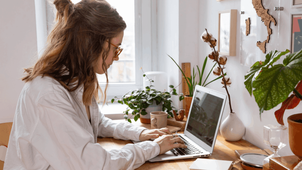 Wedding pro reviewing the best marketing blogs and planning 2026 marketing strategies on a laptop in a home office.