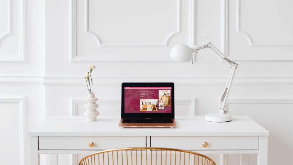 Laptop open to the Boda Bliss website on a white desk with modern decor