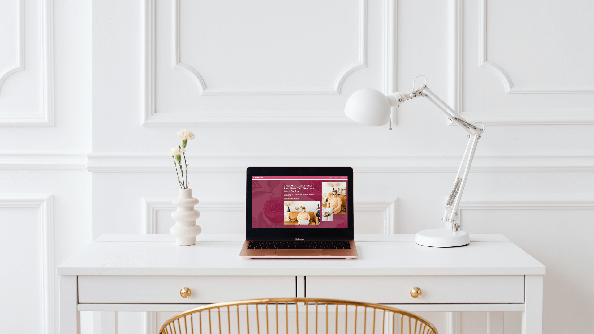 Laptop open to the Boda Bliss website on a white desk with modern decor
