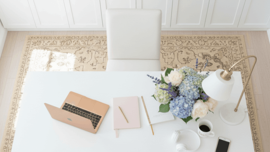 Organized workspace for a wedding professional with notebooks and a laptop showing a clean business system setup for consistent leads.