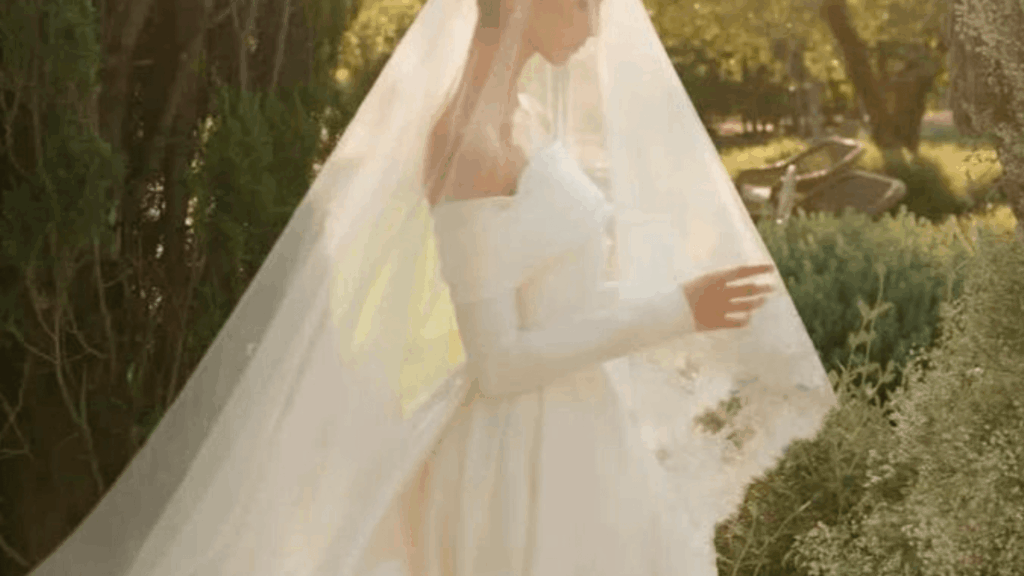 Bride in a flowing veil walking through a garden setting, representing emotional, romantic wedding trends shaping 2026 celebrations.