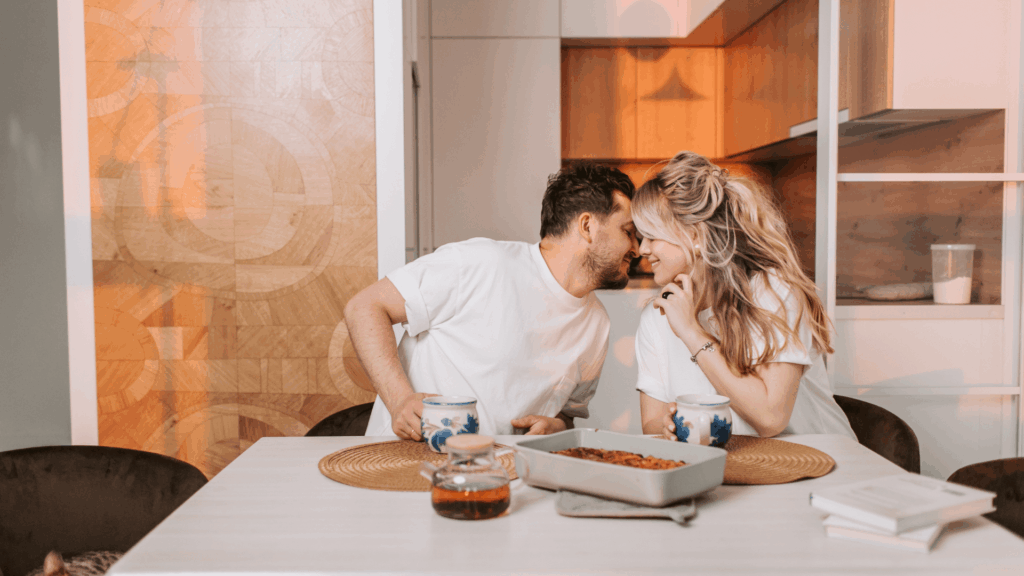 Engaged couple embracing and smiling during an engagement photo session in an outdoor city setting.