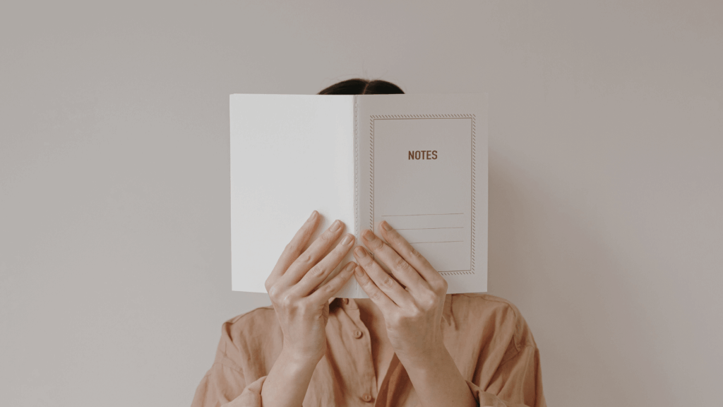 Business owner reflecting and taking notes during a marketing review with guidance from Boda Bliss