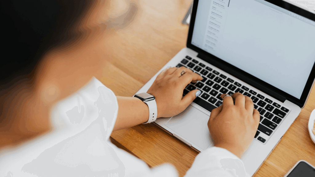 Wedding professional tracking monthly KPIs and marketing metrics on a laptop