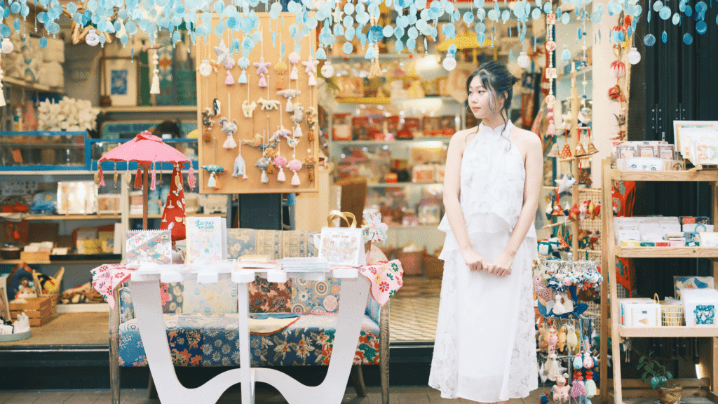 Small boutique business owner standing in a colorful storefront representing local small businesses improving their AI search visibility