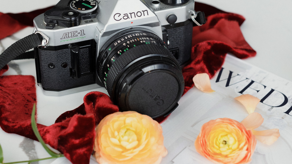 Vintage Canon camera styled with flowers and wedding details representing content strategy and marketing systems for photographers.