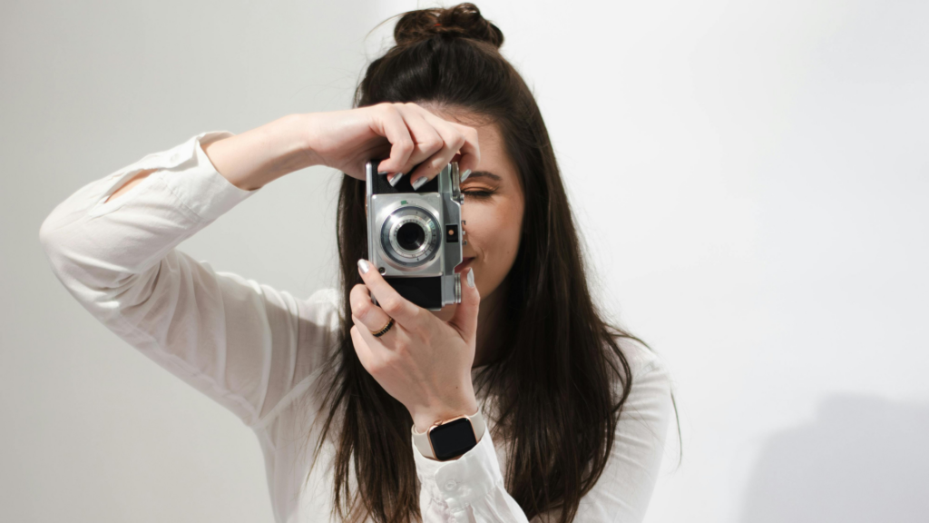 Wedding photographer holding a vintage camera representing a marketing systems case study for creative business visibility and client inquiries.