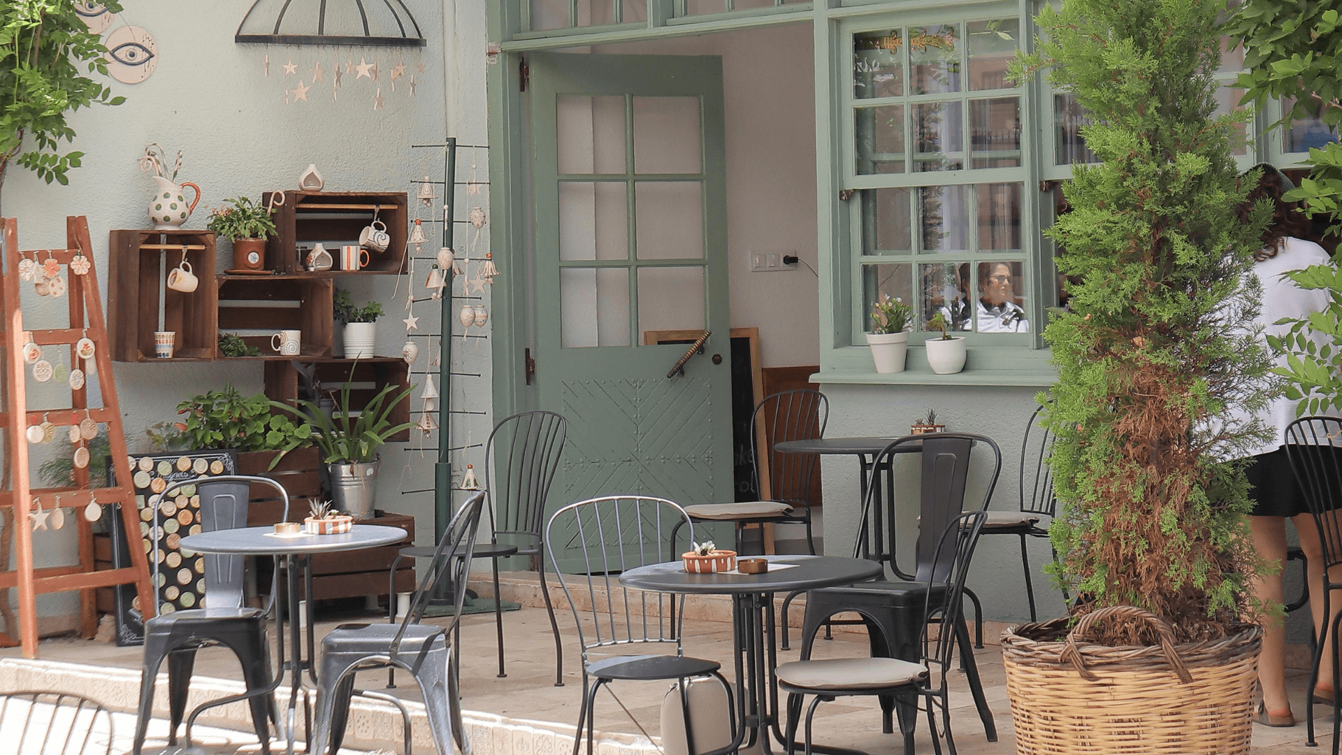 Cozy outdoor café with garden seating, plants, and handmade decor, illustrating a real local business customers might discover through AI search.