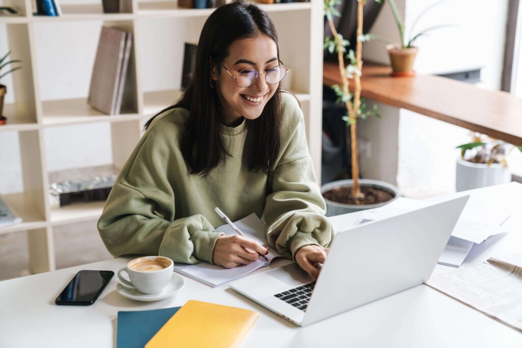 Small business owner researching how AI recommends businesses using a laptop in a bright home office.