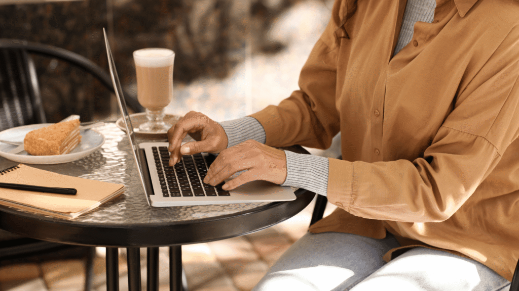 Author working on a book marketing plan on a laptop at a café